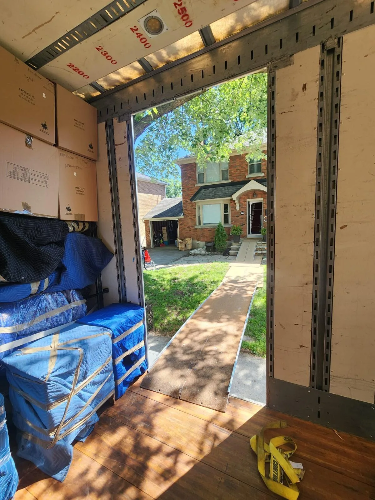View from inside a Klacar trailer with the ramp down at a house on moving day