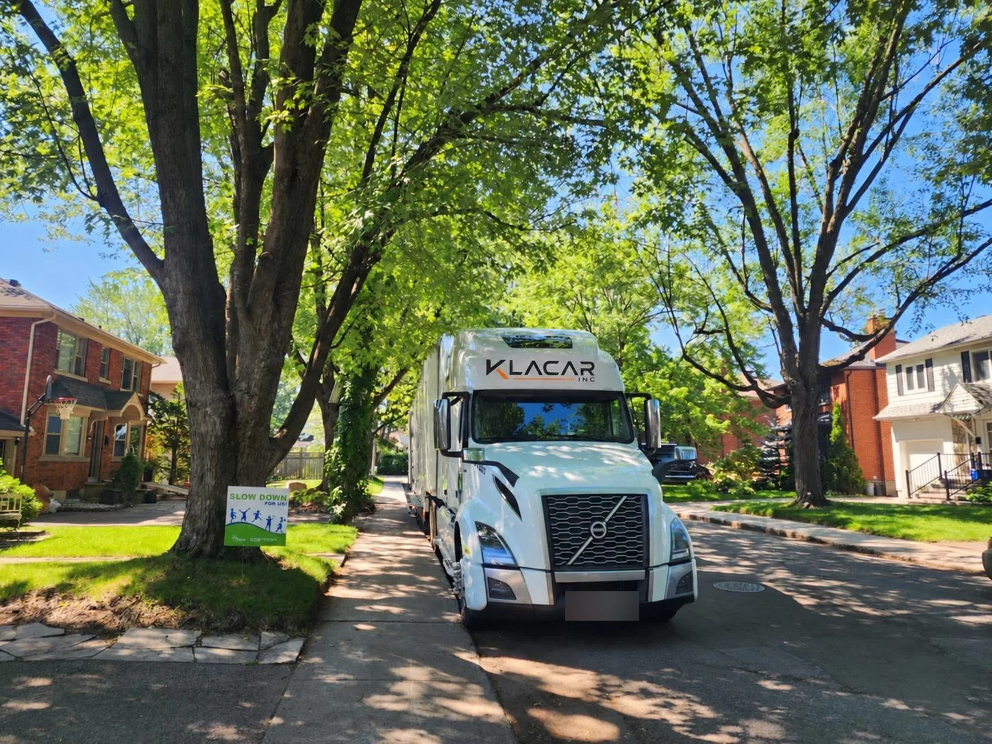 Klacar tractor-trailer on a tree-lined residential street